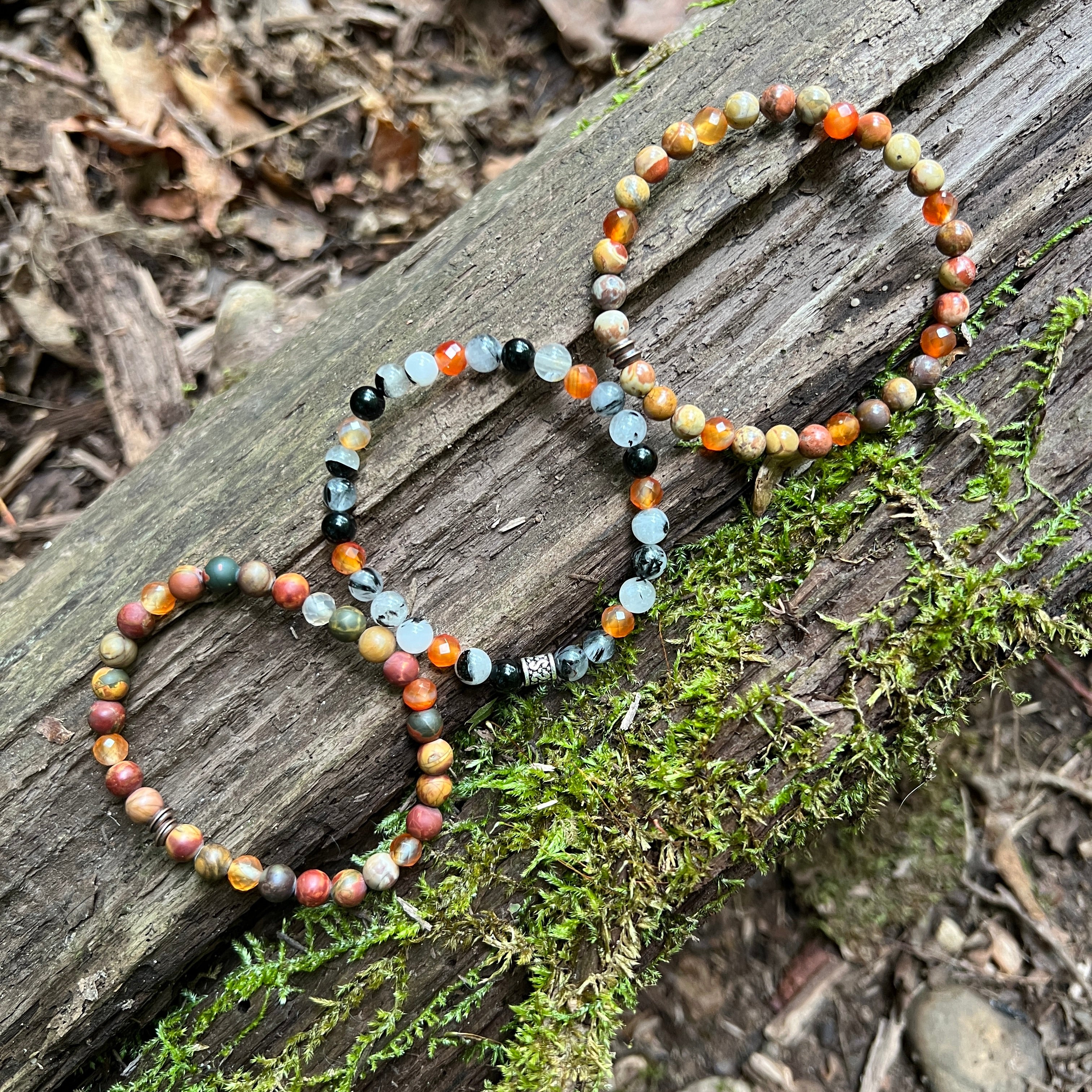 3 beaded bracelets from Fall Collection with a log and moss background