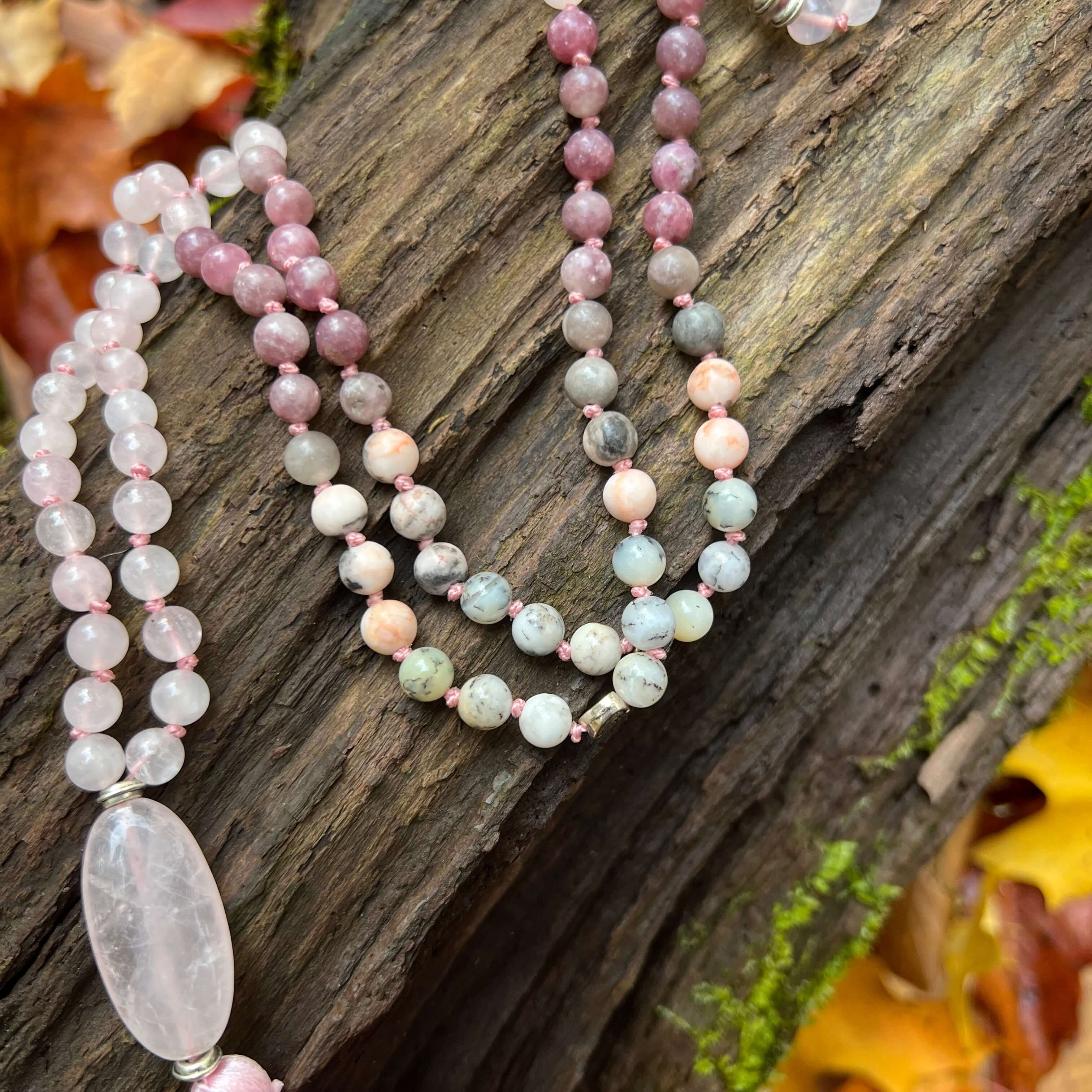 Loving Growth Mala Introducing our exquisite Loving Growth Mala Necklace crafted with high-quality Rose Quartz, Lepidolite, Pink Zebra Jasper, and Dendritic Opal. This beautifully designed mala is not just a piece of jewelry; it's a spiritual companion th